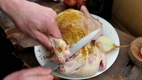 A man prepares a turkey or chicken for dinner Stock Footage 147949267