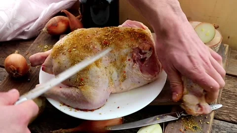 A man prepares a turkey or chicken for dinner,cuts the chicken with a knife Stock Footage 147949351