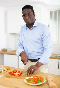Man prepares a vegetable salad in the kitchen Foto stock