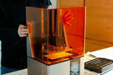 Man preparing a 3d resin printer before use 写真素材