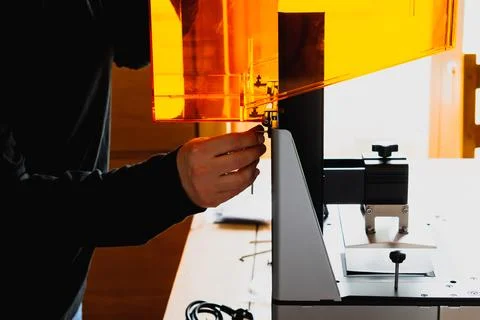 Man preparing a 3d resin printer before use Stockfoto's