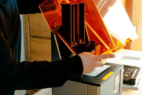 Man preparing a 3d resin printer before use Stockfoto's