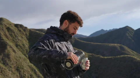 Man preparing and drinking traditional mate outdoors, surrounded by green Stock Footage 328281589