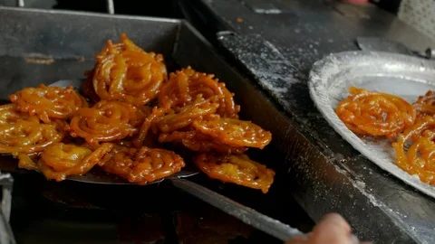 A man preparing and putting fresh and delicious deep fried jalebis Stock Footage 112772954