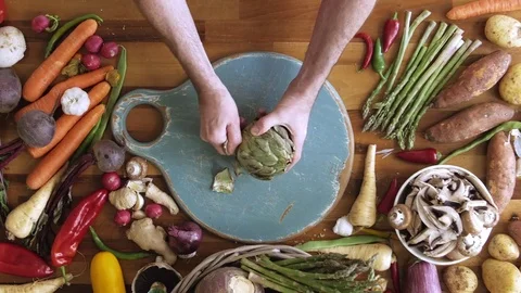 Man preparing artichoke on cutting board in kitchen Stock Footage 70074002