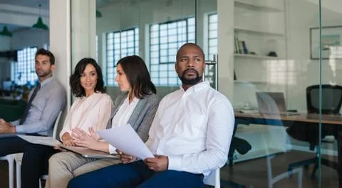 Man preparing to be interviewed while waiting with other applicants Stock Photos
