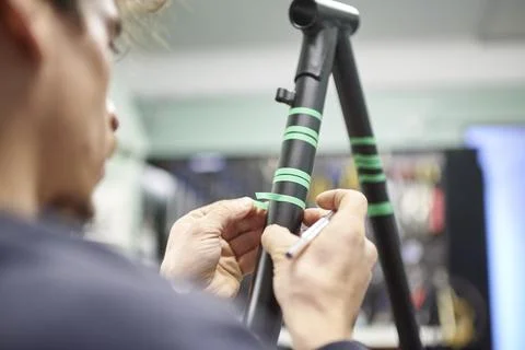 Man preparing a bicycle frame with masking tape for a custom painting design. Foto stock