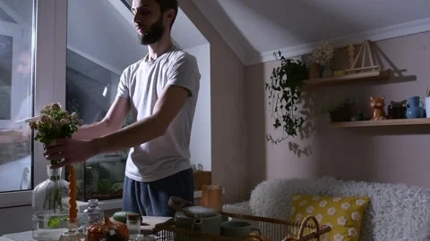 Man preparing breakfast in bed at home, placing a rose as a romantic gesture Vidéo 330128448