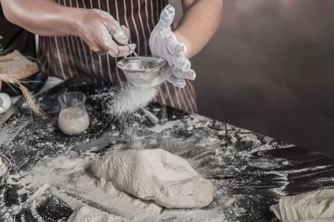 Man preparing buns at table in bakery 写真素材