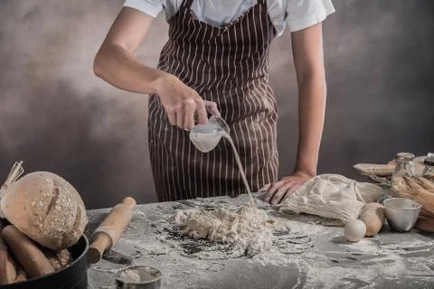 Man preparing buns at table in bakery Foto stock