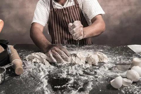Man preparing buns at table in bakery 写真素材