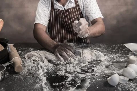 Man preparing buns at table in bakery 库存照片
