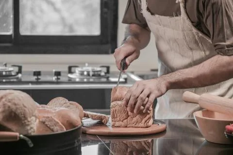 Man preparing buns at table in bakery Фото