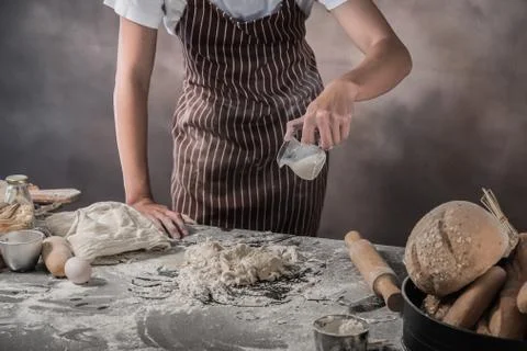 Man preparing buns at table in bakery Фото
