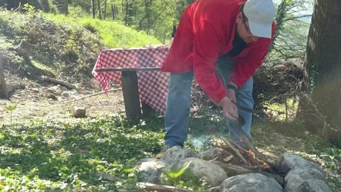 Man Preparing Campfire Near River During Picnic in Countryside, Outdoor Survival 스톡 동영상 333523067