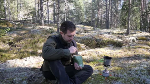 Man Preparing Camping Meal in Forest Clearing 库存影片 333581477