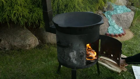 Man preparing cauldron for cooking, man burning fireplace for cooking Stock-Footage 131537852