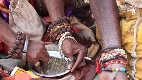 Man preparing a cigarette to smoke marijuana with chillum in Varanasi, India Stock Footage 77164828