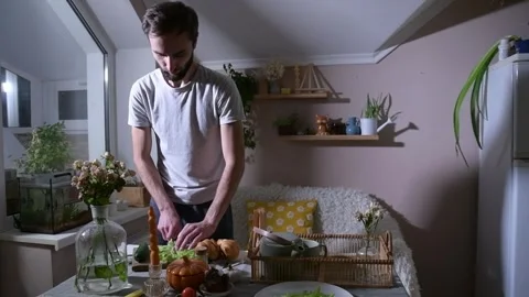 Man preparing croissants for breakfast in bed, filling them with lettuce 库存影片 330128460
