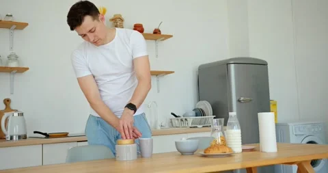 Man preparing a cup of coffee in the kitchen of his house. Stock Footage 279405782