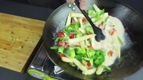 Man preparing curry vegetables with cocount milk on the wok pan Stock Footage 59847521
