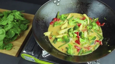 Man preparing curry vegetables with cocount milk on the wok pan 스톡 동영상 59847590