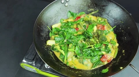 Man preparing curry vegetables with cocount milk on the wok pan 스톡 동영상 59847649