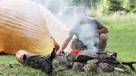 Man preparing a delicious kebab near the tent. The process of cooking kebabs Stock Footage 247336258