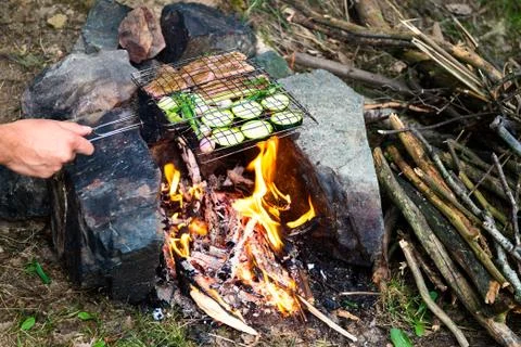 Man preparing dinner on campfire, adventure lifestyle camping vacation concep Foto stock