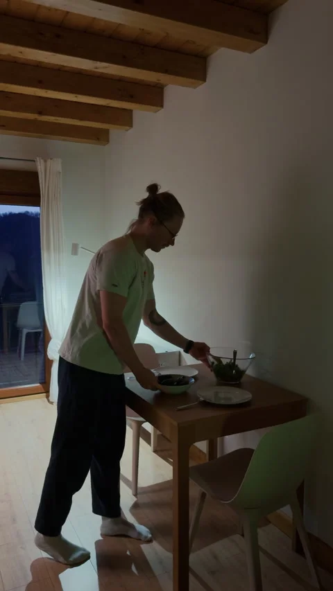 Man preparing dinner table at home cozy evening lifestyle scene 스톡 동영상 334547889