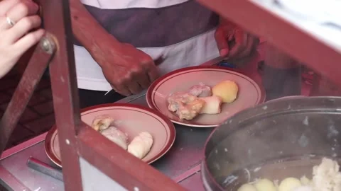A man preparing a dish called 'Batagor' to customer on the street of Malang. Stock Footage 219464895