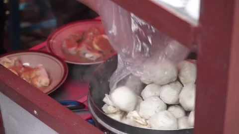 A man preparing a dish called 'Batagor' to customer on the street of Malang. Stock Footage 219465148