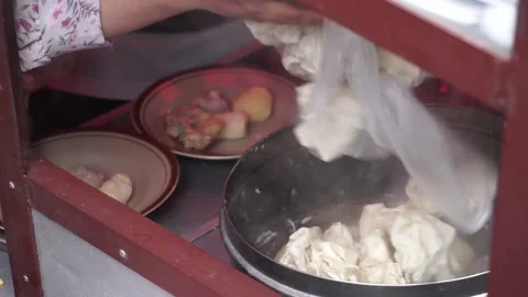 A man preparing a dish called 'Batagor' to customer on the street of Malang. Stock Footage 219465171