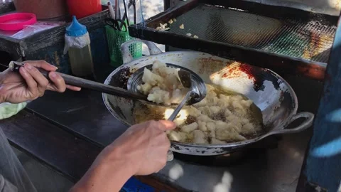 A man preparing a dish called 'batagor' to customer on the street Stock Footage 249915103
