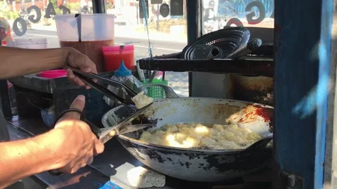 A man preparing a dish called 'batagor' to customer on the street Stock Footage 249915167