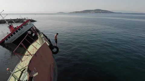 A man preparing to dive from ran aground ship Stock Footage 211089226