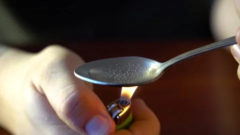 Man Preparing Dose Of cocaine by heating it with lighter in spoon. Close up. Foo Stock Footage 86044853