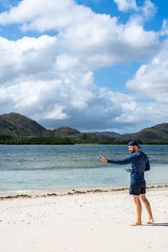 Man preparing drone for flight on tropical beach Stock Photos