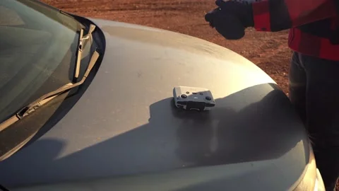 Man preparing drone to fly and attaching cell phone on controller to Stock Footage 232364036