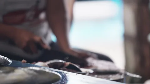 Man preparing fish on a cutting board outdoors by the sea with a knife Video stock 328031245