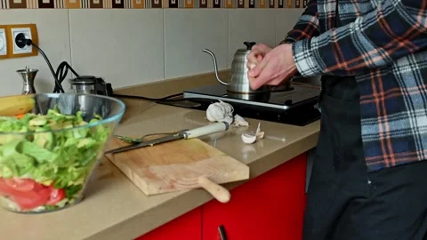 Man Preparing Food in Modern Kitchen with Fresh Vegetables and Cooking Tools Stock Footage 302640844