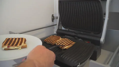 Man preparing fresh toast in toaster Stock Footage 145717579