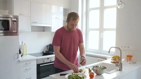 Man preparing fresh vegetable salad in white kitchen Stock Footage 138750746