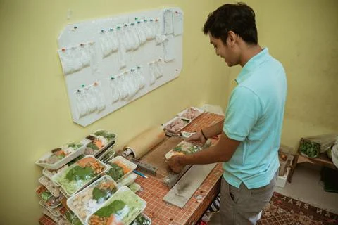 Man preparing fresh vegetables using plastic wrap to wrap vegetable Stock Photos