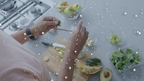 Man preparing fruit on kitchen counter, picking grapes and threading pieces into Stock Footage 333911397