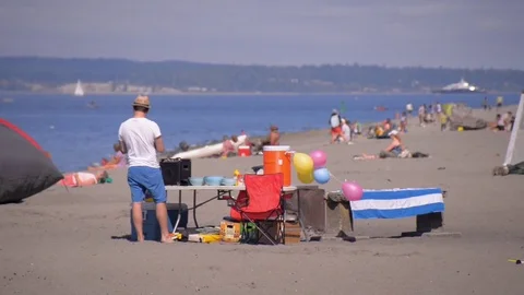 Man preparing for fun at golden gardens beach, seattle. bbq balloons Stock Footage 83397352