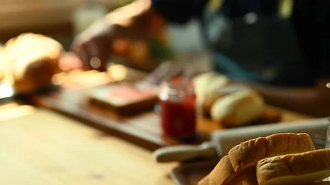Man preparing a healthy breakfast, spreading strawberry jam on slice of bread 스톡 동영상 239528644