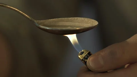 Man preparing heroin dose in spoon with lighter, drugs dependence, death risk 库存影片 87248944