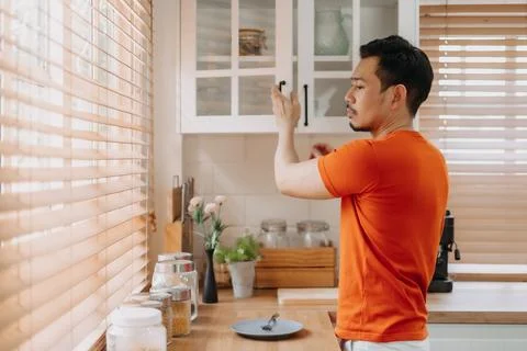 Man preparing his easy breakfast in the kitchen in warm light morning. Foto stock
