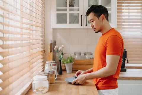 Man preparing his easy breakfast in the kitchen in warm light morning. Stock Photos